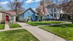 View of front of property with concrete driveway, stone siding, and a front yard