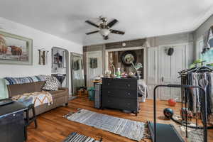 Living area featuring a ceiling fan, arched walkways, and wood finished floors