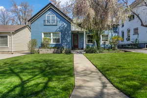 Bungalow-style home featuring stucco siding and a front lawn