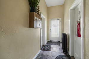 Doorway to outside with baseboards and a textured wall