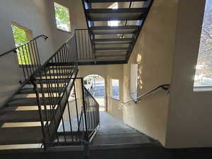 Staircase with plenty of natural light and a towering ceiling