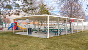 Surrounding community with a lawn, fence, and playground community