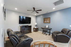 Living area with carpet, visible vents, ceiling fan, and recessed lighting