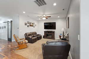 Living area with recessed lighting, visible vents, a barn door, and hardwood / wood-style flooring