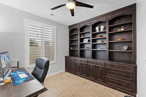 Home office featuring visible vents, carpet flooring, baseboards, and ceiling fan