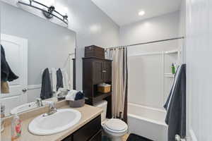 Full bathroom with toilet, shower / tub combo, and vanity
