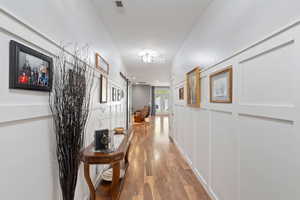 Hallway featuring wood-type flooring and visible vents