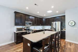 Kitchen with appliances with stainless steel finishes, visible vents, a toaster, and baseboards