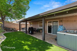 Exterior space with a hot tub, fence, and a patio area