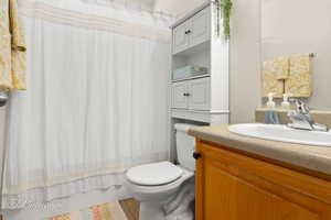 Bathroom featuring toilet, tile patterned flooring, and vanity