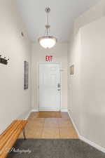 Entryway featuring visible vents, baseboards, light tile patterned floors, and light colored carpet