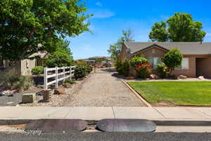 View of property exterior featuring a tiled roof, a lawn, fence, and stucco siding