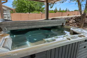 Exterior details featuring a hot tub and fence