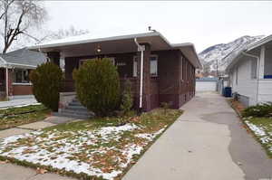 Bungalow with an outdoor structure, brick siding, central air condition unit, a mountain view, and a detached garage