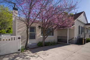 View of front of house with brick siding, fence, and cooling unit