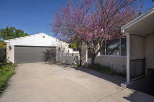 View of property exterior featuring a garage, a gate, an outbuilding, and brick siding