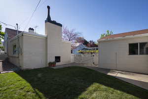 View of yard with fence, a gate, and a patio area