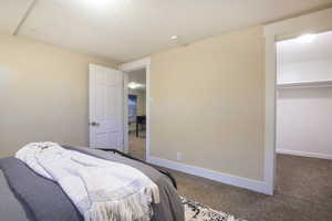Bedroom with baseboards, carpet flooring, a walk in closet, and a closet