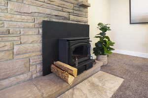 Details featuring baseboards, carpet, and a wood stove