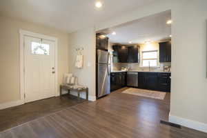 Kitchen with light countertops, backsplash, baseboards, and appliances with stainless steel finishes