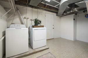 Washroom featuring laundry area and washing machine and clothes dryer