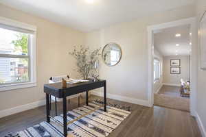 Office space with plenty of natural light, baseboards, and wood finished floors