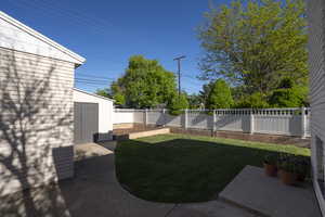 View of yard featuring a fenced backyard, an outbuilding, a patio area, and a storage shed