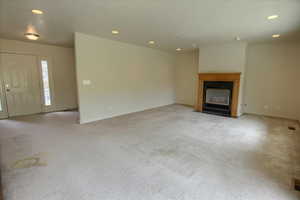 Family room with recessed lighting, a fireplace with flush hearth, and light carpet