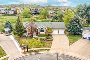Ranch-style house featuring concrete driveway, a residential view, a mountain view, a garage, and golf course
