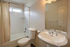 Full bathroom with a sink, toilet, and shower / tub combo
