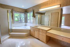 Master bathroom with tile patterned floors, a shower, a bath, and vanity