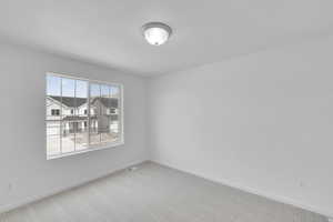 Carpeted spare room with baseboards and visible vents