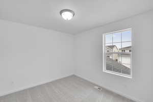 Carpeted empty room with baseboards and visible vents