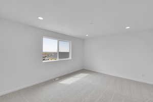 Spare room with carpet floors, baseboards, recessed lighting, and visible vents