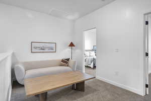 Sitting room with baseboards, carpet flooring, and attic access