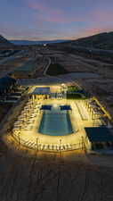 Pool at dusk with a mountain view and area for grilling