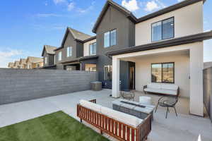 Rear view of property with stucco siding, a patio area, and outdoor lounge area
