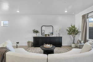 Living room featuring baseboards, recessed lighting, and light wood-style floors