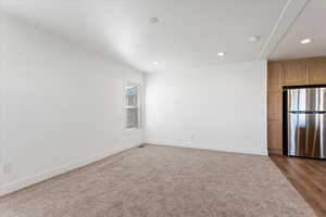Empty room featuring recessed lighting, baseboards, and dark wood finished floors