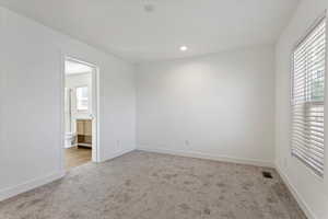 Carpeted empty room featuring baseboards, recessed lighting, and visible vents