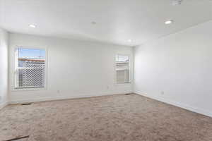 Spare room with baseboards, recessed lighting, and carpet