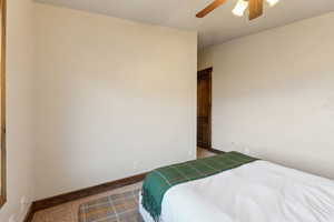 Bedroom with baseboards, ceiling fan, and carpet