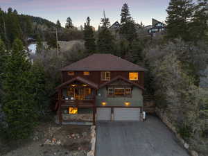 Chalet / cabin featuring a garage and aphalt driveway