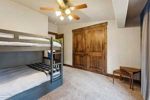 Bedroom featuring baseboards, light carpet, and a ceiling fan