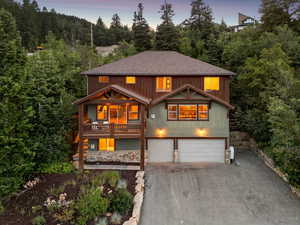 Rustic home with asphalt driveway, an attached garage, and a shingled roof
