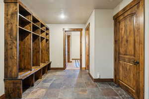 Mudroom featuring baseboards and stone tile flooring