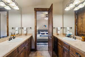 Bathroom featuring a sink, ceiling fan, two vanities, and connected bathroom