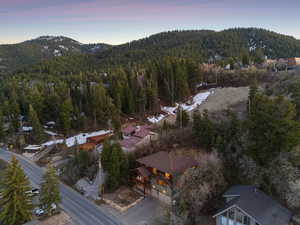Aerial view at dusk featuring a mountain view and a wooded view