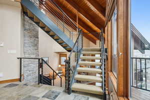 Stairs with beamed ceiling, baseboards, and wooden ceiling