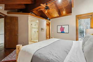 Bedroom featuring wood-type flooring, wooden ceiling, ensuite bath, and lofted ceiling with beams